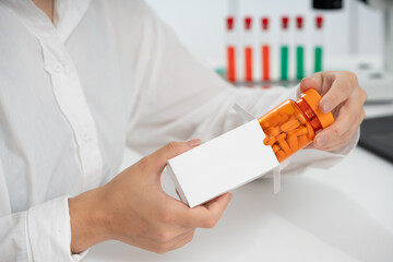 Poster - young female medical worker takes out a bottle of pills from a cardboard box