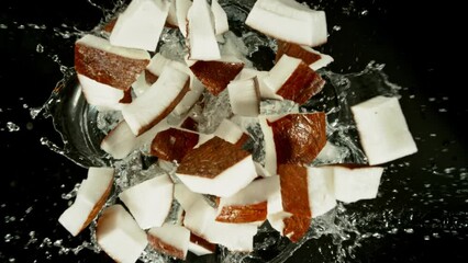 Fototapete - Super Slow Motion of Falling Coconut Slices into Water, Black Background. Filmed on High Speed Cinema Camera, 1000 fps. Camera Tracking the Target.