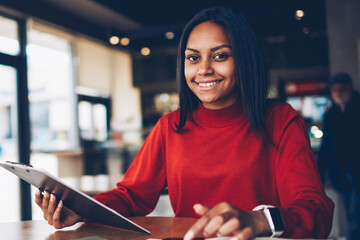 Portrait of afro american businesswoman checking plan for startup satisfied with creative solutions.Prosperous administrative manager making financial research of incomes enjoying job in cafe