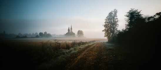 Wall Mural - Vintage Photography: atmospheric Isolation - Church in the foggy countryside.
