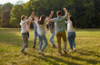 © Studio Romantic - Group of young people having fun and play roundelay dancing in circle in park. Company of funny friends holding hands while walking in circle in park on sunny summer day. Concept of friendship.