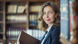 © Tetiana - A confident female lawyer with glasses holds a folder in her office against the backdrop of bookshelves and smiles softly, demonstrating professionalism and experience. copy space