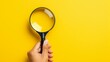 © Media Srock - Hand holding magnifying glass on isolated yellow background