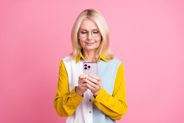 Sticker - Photo of elegant aged lady use smart phone wear shirt isolated on pink color background