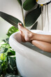 © EASY 2 SHOOT/Stocksy - Persons Feet in Bathtub Surrounded by Plants