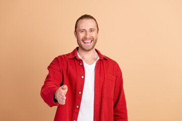 Poster - Photo of nice young man handshake you wear red shirt isolated on beige color background