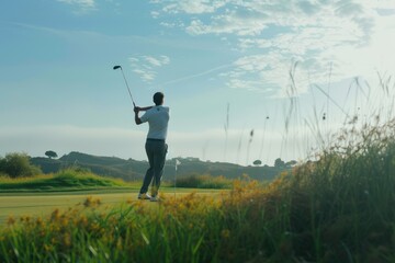 Wall Mural - Man focusing on golf shot in lush landscape