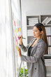 © ArLawKa - Asian businesswoman sits behind a desk looking at a monitor with a stock market graph tracking market prices. Big data analysis helps business in modern business office