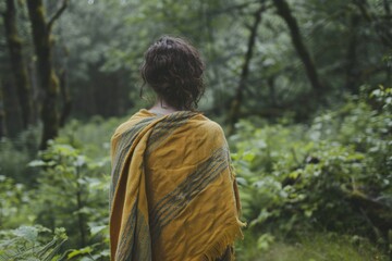 Aufkleber - A woman wrapped in a blanket standing in the woods. Suitable for nature and lifestyle concepts
