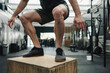 © Nicola Suttle/Stocksy - Unrecognizable man box jumping in crossfit gym