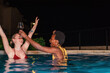 © Milles Studio/Stocksy - Excited emotional girls having fun at night pool