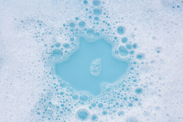 Wall Mural - Detergent foam bubble on water. Blue background, Soap sud