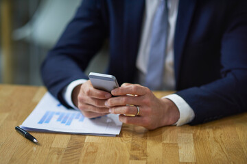 Cellphone, graph and hands with businessman, documents and reading in office for stock market research. Accountant, networking and communication in workplace for trading and analysis for company