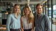 © victoriazarubina - Three business managers standing together in a modern office setting, each displaying a different expression of confidence, determination, and collaboration.