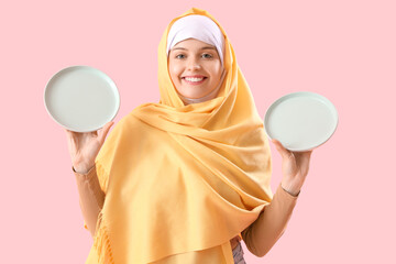 Canvas Print - Beautiful Arabian woman with empty plates on pink background