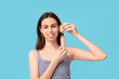 © Pixel-Shot - Beautiful young woman opening face foundation on blue background