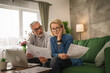 © Miljan Živković - Mature worried woman sit with her husband and hold documents bad news