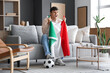 © Pixel-Shot - Young man with flag of Italy watching football game on TV at home