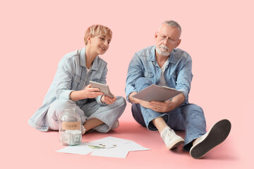 Sticker - Mature couple keeping cash records on pink background