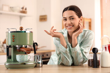 Wall Mural - Beautiful young happy woman with modern coffee machine and jar of fresh beans in kitchen