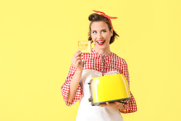 Poster - Beautiful young happy pin-up housewife with toaster and bread slice on yellow background