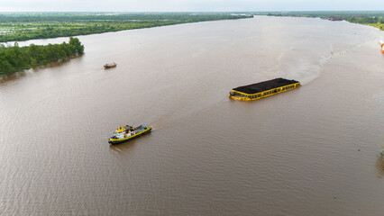 Wall Mural - aerial view of a coal barge passing through a bridge in South Kalimantan