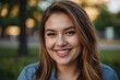 © Asfand - Smiling young woman outdoors. Close up of beautiful woman smiling with happiness while looking at camera in a park