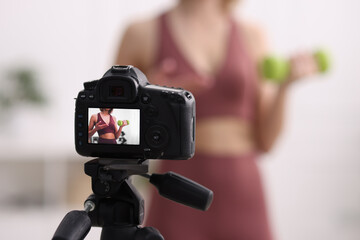 Poster - Sports blogger with dumbbell recording fitness lesson at home, focus on camera. Space for text