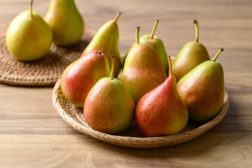 Wall Mural - Fresh pear fruit in natural basket on wooden background