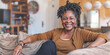 © FATHOM - Happy black woman is relaxing on her couch