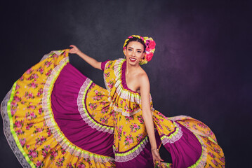 Wall Mural - A woman in a yellow and purple dress is dancing