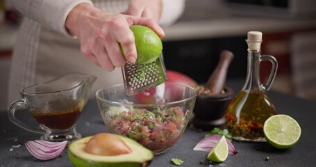 Canvas Print - Woman grates lime zest onto chopped tuna, cilantro and onion in a glass bowl cooking traditional tuna tartare