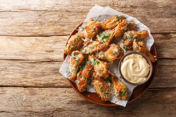 Wall Mural - Classic Garlic Parmesan Butter Chicken Wings served with mayonnaise close-up in a plate on the table. Horizontal top view from above