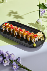 Poster - Summery sushi concept with eel roll, tobiko caviar, and unagi sauce amidst pastel floral decor