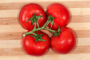 Wall Mural - Red tomatoes on branch on cutting board, top view