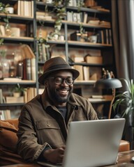 Wall Mural - A smiling man working on his laptop in a coffee shop.