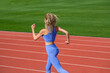 © Yevhen - Female jogger runner running outdoors, runner. Fitness woman on stadium. Young fitness woman runner running on stadium track. Woman in sportswear jogging on stadium
