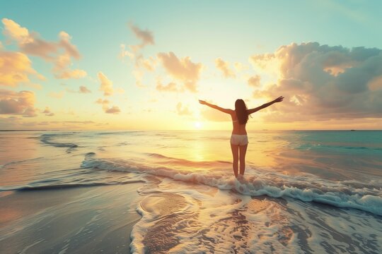 a woman standing on the beach with her arms outstretched at sunset - happiness stock photos videos