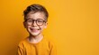 © Attasit - Happy Cute boy with big eyeglasses Isolated on solid yellow background