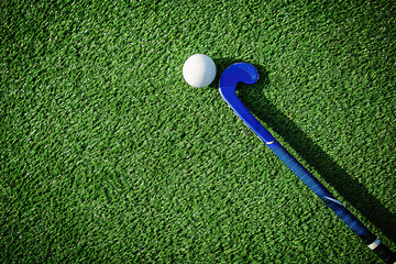 Sticker - Field hockey stick and balls on green grass. Horizontal sport theme poster, greeting cards, headers,