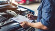 © Anna - a male auto mechanic fills out a form. Selective focus