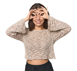 Wall Mural - Middle Eastern woman in studio showing okay sign over eyes