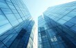 © OLGA - Modern glass buildings reflecting clear blue skies.