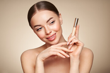 Wall Mural - portrait beautiful young woman with clean fresh skin. model with foundation makeup bottle. cosmetolo