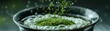 © peeradol - A macro shot of matcha powder being sifted over a frothy bowl of green tea, with traditional tea ceremony accessories displayed in soft focus