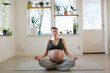 © Johnér - Pregnant young woman meditating on exercise mat at home