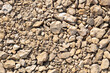 © Iuliia - Different sized beige stones and gravel of different sizes and shades covering the ground. material for landscape design or in the construction of paths. For background