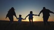 © maxximmm - family runs across the field. happy childhood concept for little child. big happy family running across the field on the grass holding hands, sunset lifestyle on the background, silhouettes