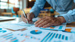© JR-50 - Business Professional Analyzing Financial Data and Charts at Desk