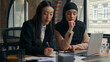 © Yuliia - Two multiracial girls business women diversity multiethnic businesswoman female in office work Arabian boss Indian mentor Muslim leader in hijab woman help Asian Korean intern girl laptop teach terms